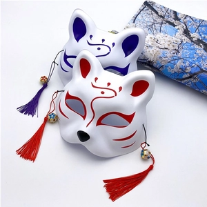 Japanese Kitsune fox masks in red and blue with decorative tassels on cherry blossom card