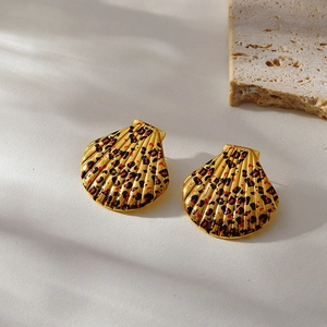 Macro shot of 18k gold shell-shaped leopard print earrings on white stone