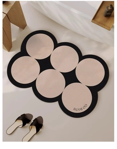 Detail view of modern pebble pattern bath mat in a cozy bathroom with minimalist decor