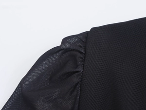 Vue détaillée du tissu en tulle noir et des coutures de la manche bouffante sur la robe