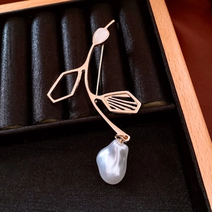 Detail of a vintage pearl brooch with gold irregular shell inlay on black velvet box