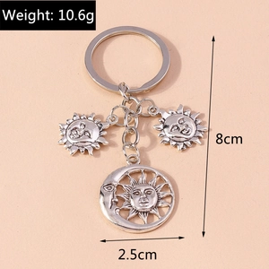 Detail view of mystic sun and moon embossed silver alloy keychain charms with dimensions