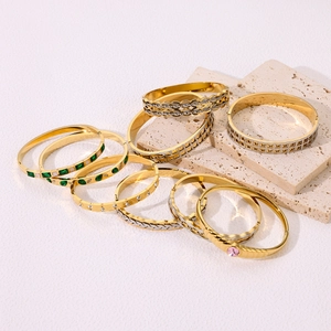 Detail of 18k gold and silver titanium steel bracelets with colorful gemstone inlays