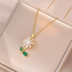 Detailed macro view of a golden sunflower necklace with sparkling zircon petals and green leaves