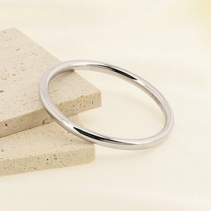 Minimalist 6mm silver hollow titanium steel bangle on a marble stone display stand