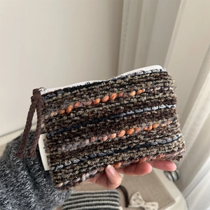 Macro shot of handwoven striped fabric texture on small pouch with Simple Wish tag
