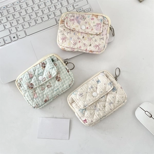 Detailed view of quilted cotton coin purses with floral, bear, and bow patterns