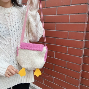 Detail of cute plush duck crossbody bag with soft faux fur texture and pink straps