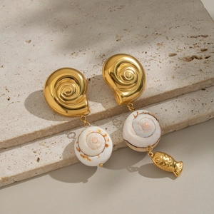 Orecchini minimalisti in oro con conchiglia e pesce su sfondo di pietra