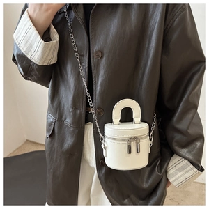 Détail du sac seau cylindrique blanc avec chaîne argentée et double fermeture éclair