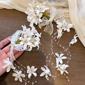 Detailed macro view of white lace floral hair clips with pearl tassel and bead fringes