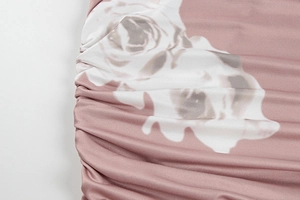 Close-up of ruched side detail and white rose floral print on a summer bodycon dress