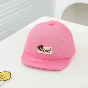 Detailed macro view of pink breathable mesh baby cap with cute bear and OK embroidery