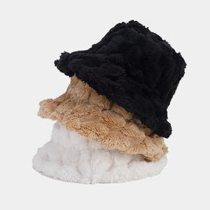 Stacked fluffy faux rabbit fur bucket hats in black, khaki, and white showing soft texture