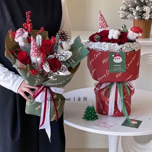 Christmas bouquet with red roses, pine cones and evergreen in festive gift wrapping