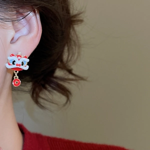 Detail of lion dance earrings with enamel finish and copper coin drop on model