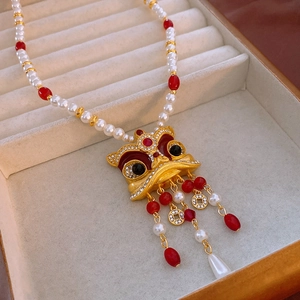 Gros plan détaillé d'un collier de perles style chinois avec pendentif danse du lion