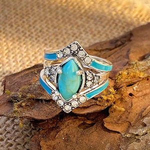 Detail of vintage silver rings set with turquoise, rhinestones and blue enamel accents