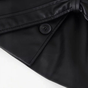 Gros plan d'une veste en similicuir noir avec coutures précises et bouton en résine