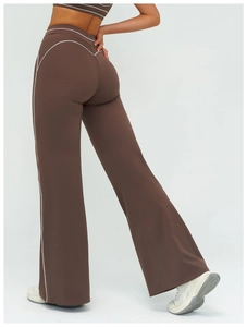 Detail view of high-waisted flared yoga pants in coffee brown with white contrast piping