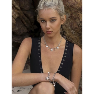 Detailed close-up of 18k gold starfish shell charms on beach necklace and bracelet set