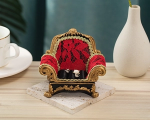 Miniature red lace and gold vintage sofa jewelry display showing rings and earrings