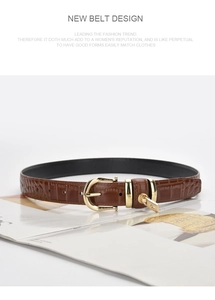 Detail of brown croc-embossed leather belt with gold buckle and padlock pendant on magazine