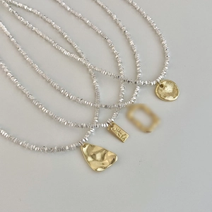 Minimalist layered silver bead necklace and bracelet with gold irregular pendants