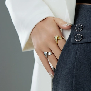 Close-up of a model wearing gold and silver irregular C-shaped geometric folding rings