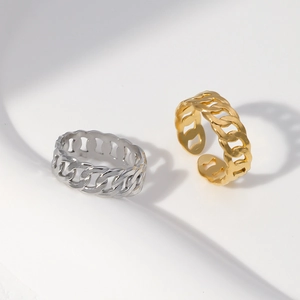 Detail of gold and silver Cuban chain rings with an adjustable open design on white waves