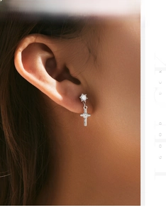 Detail of s925 sterling silver cross earrings with clear zircon stones on ear