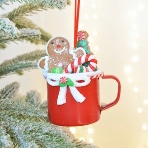 Christmas snowman gingerbread man in a red cup ornament hanging on a festive snowy tree