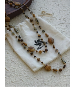 Detailed shot of bohemian beaded necklace with earthy natural stones and gold chain link