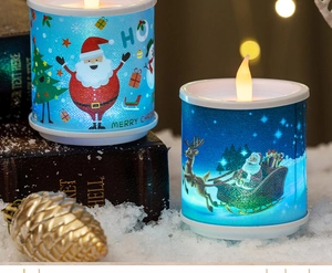 Detail of Christmas LED candles featuring Santa and reindeer prints on a snowy backdrop