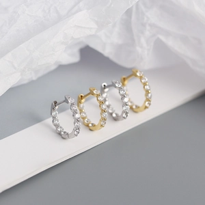 Détail de boucles d'oreilles huggies en argent et or avec pavé de micro-oxydes de zirconium