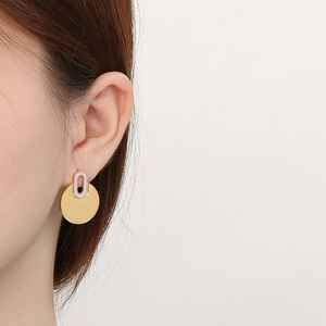 Detail of gold and lavender enamel round earring worn on model for a minimalist look