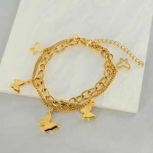Detail of gold-plated double-layer butterfly chain bracelet with matte and hollow charms