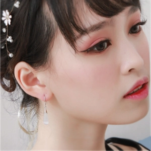 Elegant silver-plated drop earrings with moonstone pendant on female model