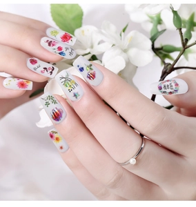 Close-up of floral nail art stickers with gold foil accents and wild rose designs