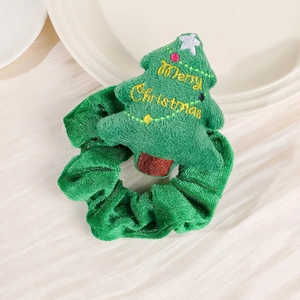 Detail of green velvet Christmas scrunchie with plush Merry Christmas tree ornament