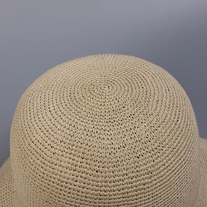 Nahaufnahme des handgeflochtenen Strohhutes mit spiralförmiger Textur und beigen Fasern