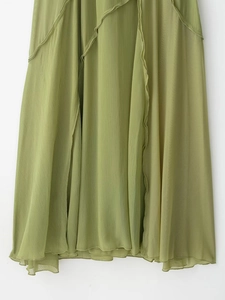 Dettaglio della trama del tessuto in chiffon verde erba e dell'orlo a onde