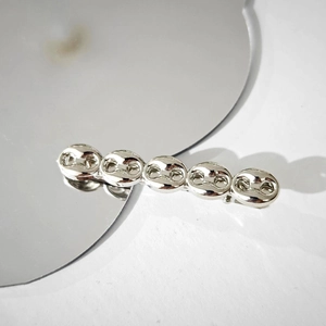 Close-up of a silver metal chain link hair clip showing glossy texture and elegant design