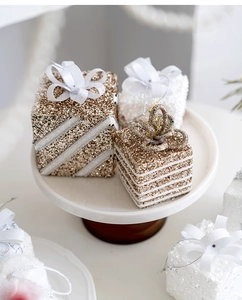 Close-up of champagne and white glitter Christmas gift box ornaments with ribbon bows