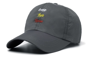 Detail of dark grey quick-dry baseball cap with letter embroidery and laser-cut vents