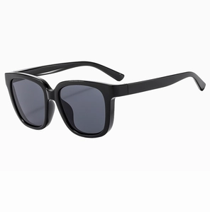 Detail view of stylish black square frame sunglasses with dark grey lenses at 45-degree angle