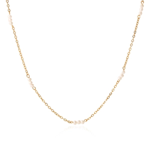 Macro detail of French vintage gold chain necklace featuring delicate white freshwater pearls