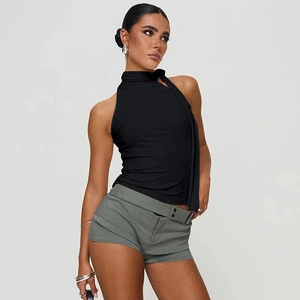 Seitenansicht des schwarzen Neckholder-Tops kombiniert mit grünen Cargo-Shorts