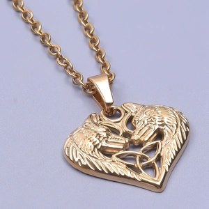 Macro shot of gold heart pendant with wolf relief and polished O-chain detail