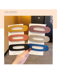 Macro view of matte hair clips in six vibrant colors showing smooth texture and finish
